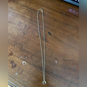 Delicate garnet colored necklace on gold chain.